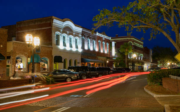 Downtown Fernandina Beach, FL at Night Downtown stores in the small town of Fernandina Beach are lit against the evening sky by ribbons of traffic light. facade store old built structure stock pictures, royalty-free photos & images