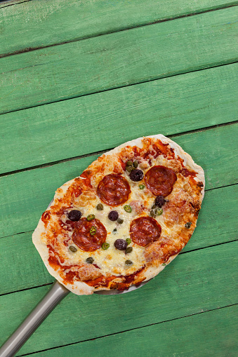Overhead of delicious italian pizza served on pizza peel