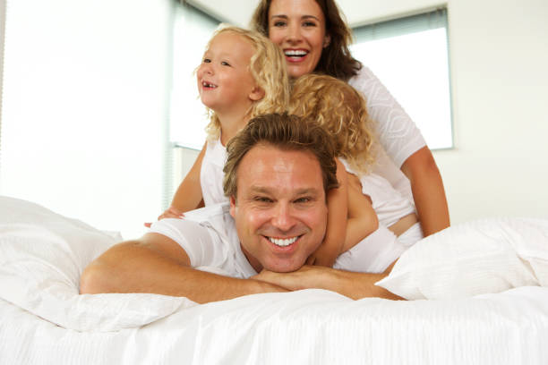 istock Happy young family enjoying in bed 656364070