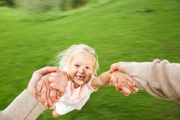 istock Cute little girl being spun in circles at park 656364084