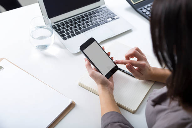 istock Rear view of woman in gray with cell phone 656366830