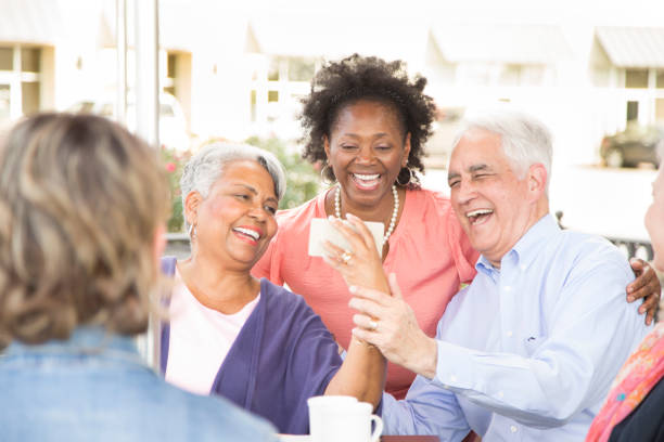 istock Multi-ethnic group of senior adult friends using technology at cafe. 656368674