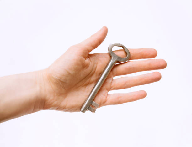 istock Large key in human hand on white background 656370488