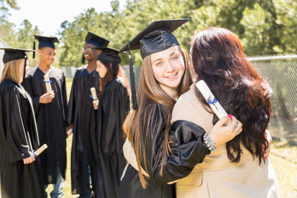 istock College, high school student hugs mom after graduation ceremony. 656382218