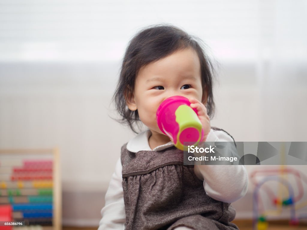 baby girl drinking water baby girl drinking water using a cup Baby Cup Stock Photo