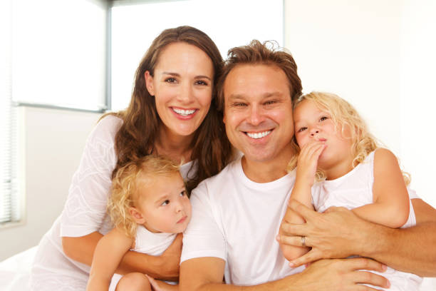 istock Loving young parents with daughters on bed at home 656395240