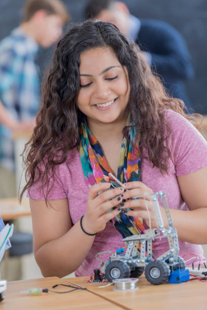 istock Happy Indian high school student builds robot at school 656396158