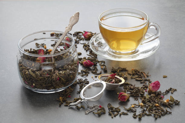 istock Spilled green tea with a rose on stone table 656396260