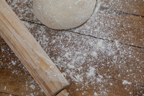 istock Rolling pin with pizza dough and flour on wooden plank 656399476