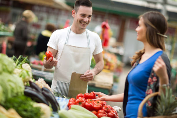 istock Young salesman smiling and holding vegetable at market 656407334