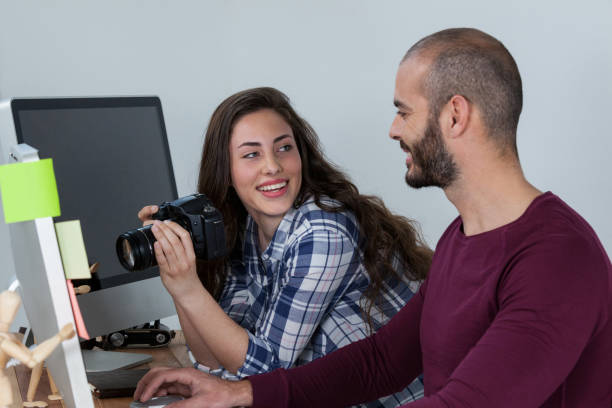 istock Photographer working at his desk with colleague 656421168