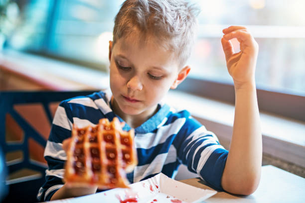 istock Little boy eating waffle with jam 656421528