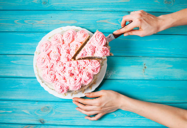 istock Woman's hands cut the cake with pink cream 656431734