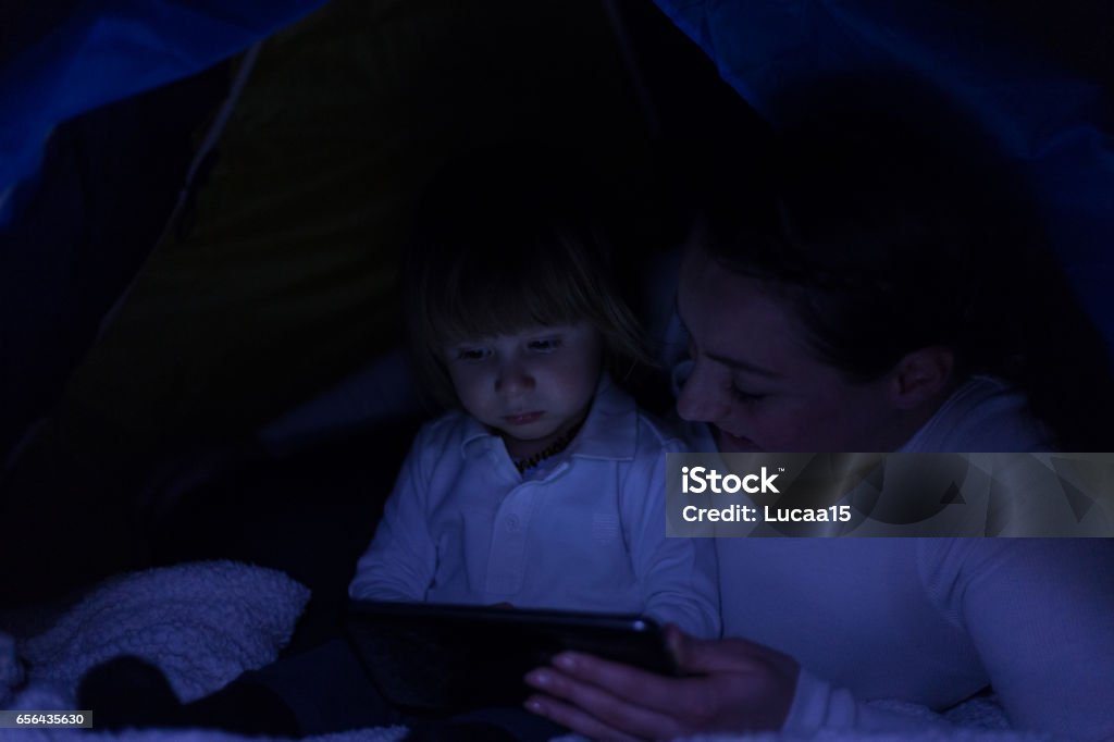 Interactive bedtime fun Mother and son watch cartoon - 
 Adult Stock Photo