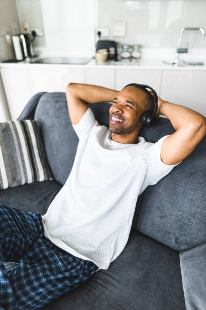 istock man listening music on the couch 656442130