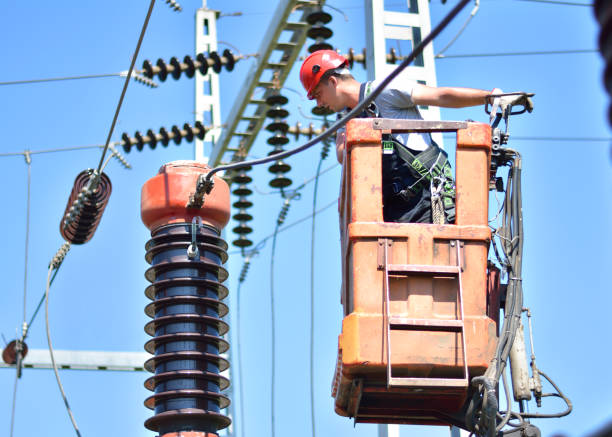 Electrician on a cherry picker repair high voltage circuit breaker Construction workers with protective workwear, hardhat and safety harness fixing power lines in electricity substation. amperage stock pictures, royalty-free photos & images