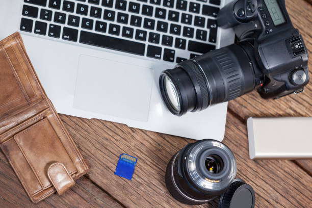 istock Close-up of digital camera, lens, memory card, laptop on table 656447270