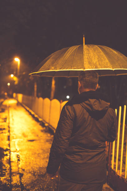 istock Man walking at night in the rain. 656449148