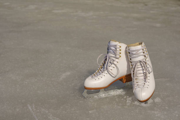 istock White figure skates on the spring ice in sunny day 656451828