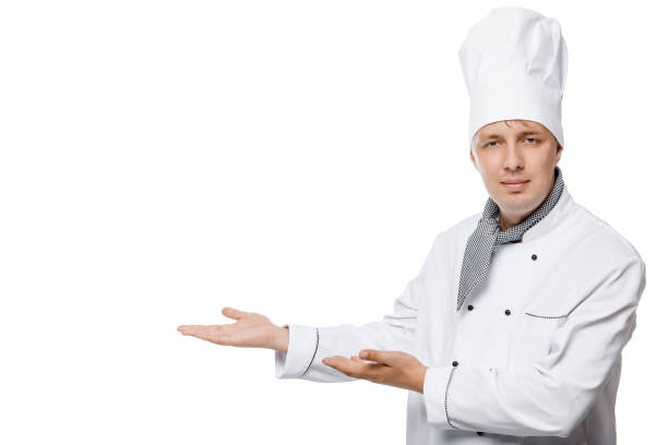 istock Cook in a white suit presents a space for inscription left on a white background 656464280