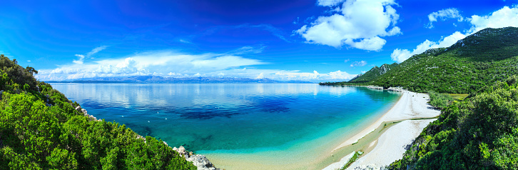 Beach, crystal clear water in Adriatic Sea and Green Mountains