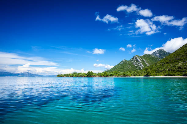 paysage idyllique - île, limpide mer adriatique et ciel bleu avec des nuages blancs - green sky water wave photos et images de collection