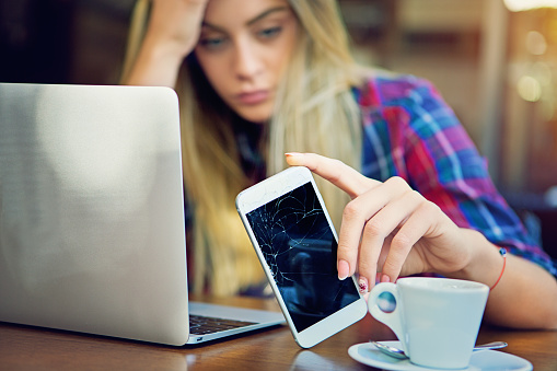 Young girl is devastated after her mobile phone is fall down.