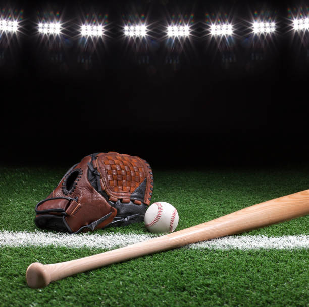 istock Baseball mitt ball and bat at night under stadium lights 656479412