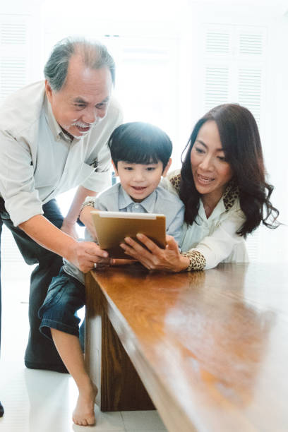 istock Grandson and grandparents using digital tablet 656480192
