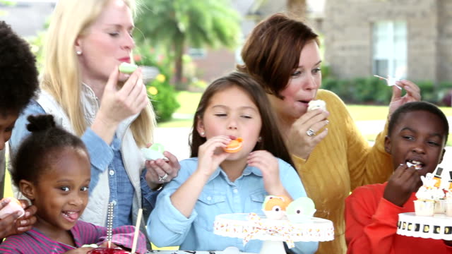 Large group of women, children eating halloween treats