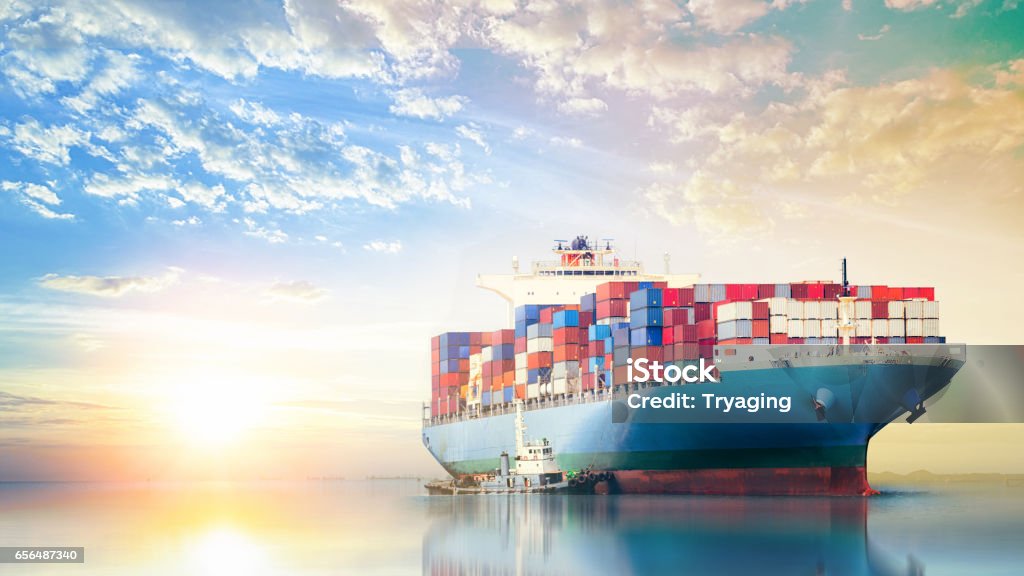 International Container Cargo ship in the ocean at sunset sky, Freight Transportation, Nautical Vessel Container Ship Stock Photo