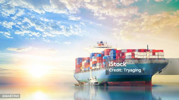 International Container Cargo Ship In The Ocean At Sunset Sky Freight Transportation Nautical Vessel Stock Photo - Download Image Now