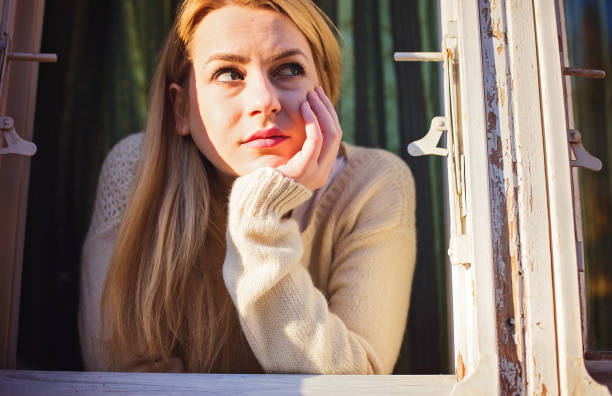 Sensual woman at window on sunny morning