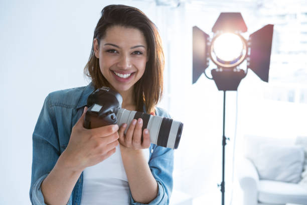 istock Happy female photographer standing in studio 656508826