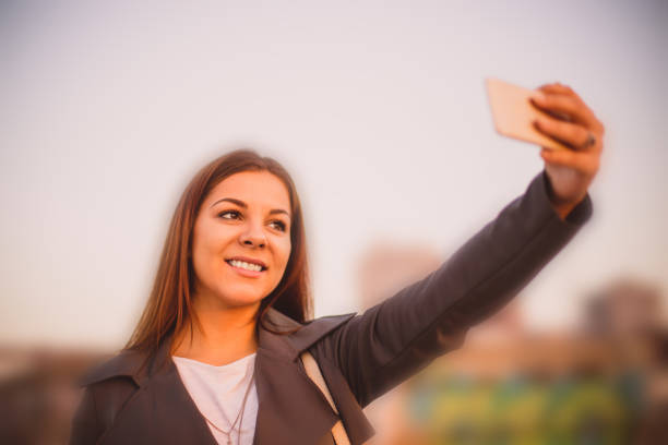 istock Lovely girl taking a selfie on the river bridge 656511700
