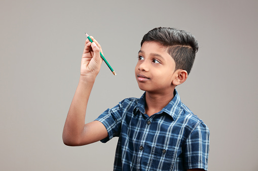 Portrait of a boy writing with a pencil