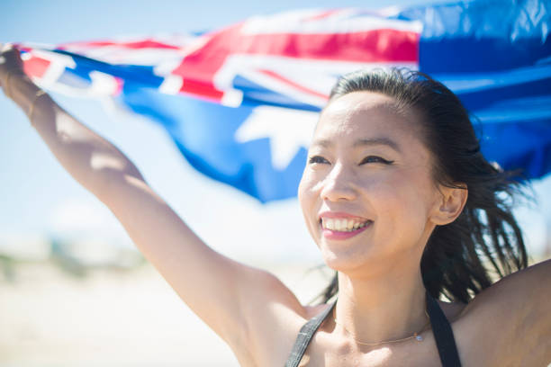 Mixed race Australian young woman at the beach with the Australian National Flag.