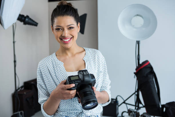 istock Happy female photographer standing in studio 656526350