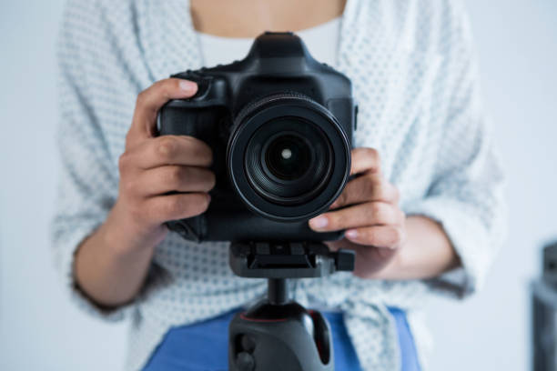 istock Mid section of female photographer adjusting digital camera 656527184