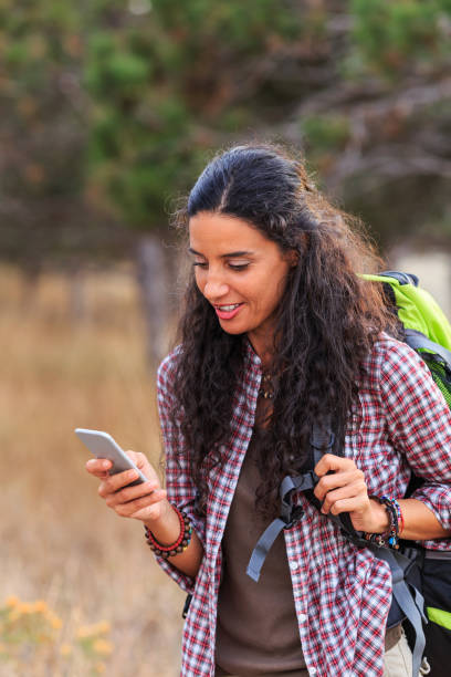 istock Young woman hiking and using smart phone in nature 656527400