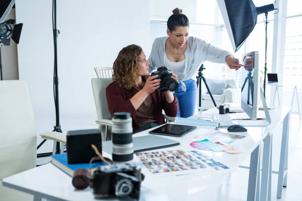istock Photographers reviewing captured photos in digital camera 656528142