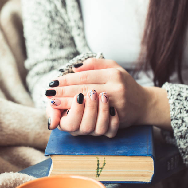 istock Young woman reading book, close-up, on home interior 656530556