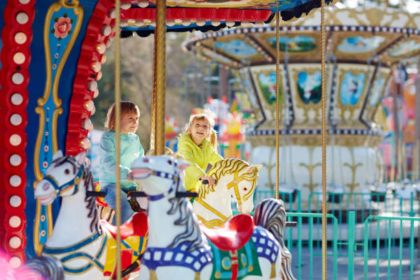 istock Happy little sisters riding on carousel 656534802