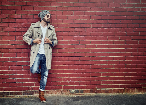 Shot of a fashionable young man wearing urban wear and posing against a brick wall
