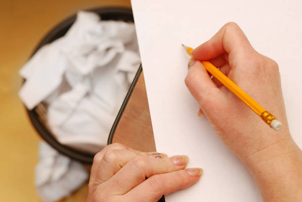 istock Hand holding a yellow pencil  on a white paper 656535288
