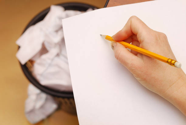 istock Hand holding a yellow pencil  on a white paper 656535352