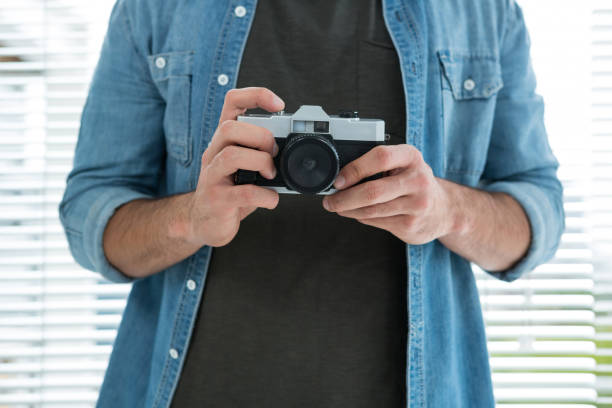istock Mid section of male photographer with old fashioned camera 656542438
