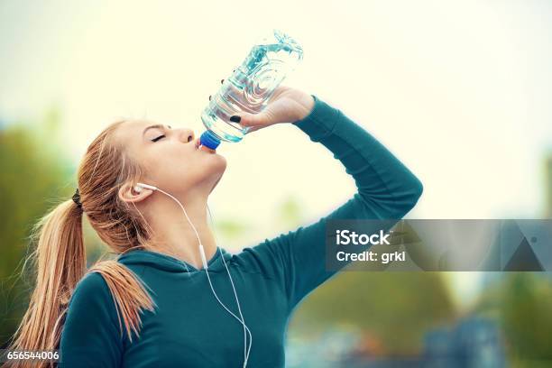 Blonde Frau Ist Trinkwasser Nach Dem Joggen Stockfoto und mehr Bilder von Athlet - Athlet, Trinken, Aktivitäten und Sport