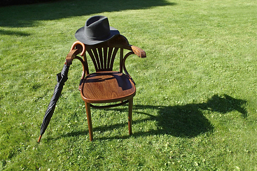 Hat, umbrella and a chair on the grass