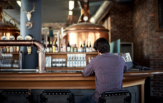 Rearview shot of a man sitting at a bar counter